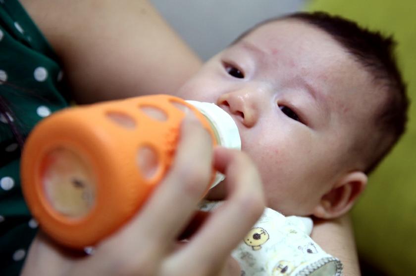 A baby drinks milk from a bottle. u00e2u20acu201c Picture by Saw Siow Feng