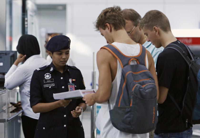 A police officer checks the travel documents and passports of passengers at Kuala Lumpur International Airport in Sepang March 9, 2014. u00e2u20acu201d Reuters pic