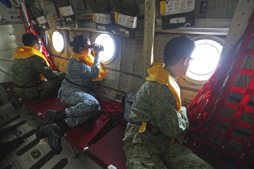 Military personnel look out of a Republic of Singapore Air Force C130 transport plane as they search for the missing Malaysia Airlines MH370 plane over the South China Sea March 11, 2014. u00e2u20acu201d Reuters pic