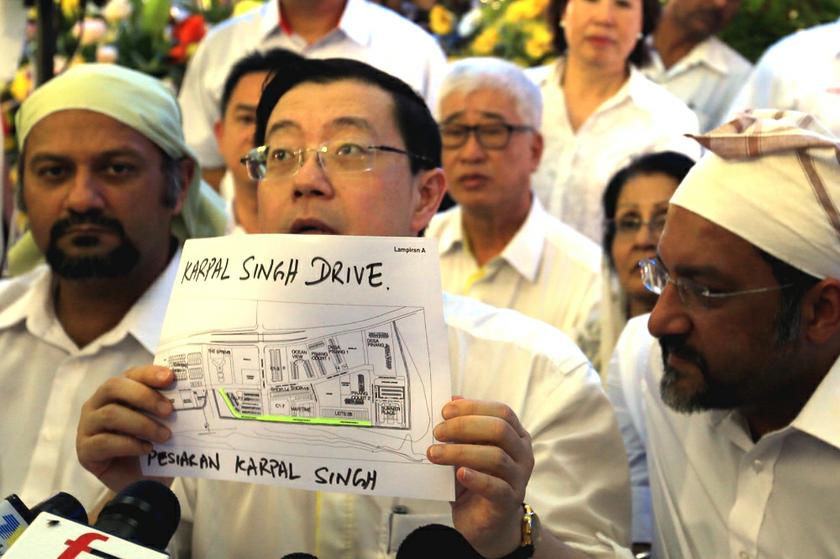 Penang Chief Minister Lim Guan Eng (centre) holds up a map depicting the promenade near Jalan Sungai Pinang which will be renamed u00e2u20acu02dcKarpal Singh Driveu00e2u20acu2122 in honour of the DAP veteran. u00e2u20acu201d Pictures by Saw Siow Feng