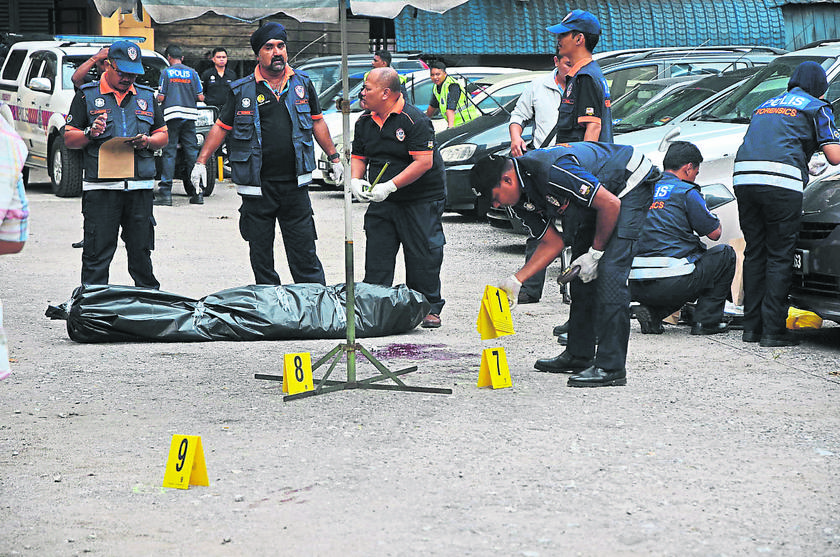 A team of forensics police officers investigate the scene where businessman Ahmad Najadi was shot dead. u00e2u20acu201d Picture by Nawar Firdaws