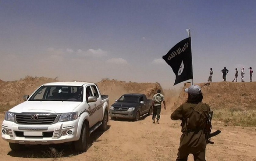 An image from the jihadist Twitter account Al-Baraka news on June 11, 2014 allegedly shows a militant of the jihadist group Islamic State of Iraq waving the Islamic Jihad flag as vehicles drive on a newly-cut road through the Syrian-Iraqi border. u00e2u20acu201d AFP 