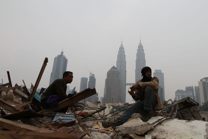 A blanket of haze that shrouds the city landscape can be seen as a foreign workers take a break at a residential area that was demolished for development in Kuala Lumpur, October 7, 2014. u00e2u20acu201d Picture by Yusof Mat Isa  