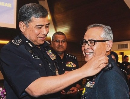 Khalid pins a promotion badge on Acryl Sani, who was promoted to the rank of commissioner of police, October 7, 2014. u00e2u20acu201d Picture by Bernama