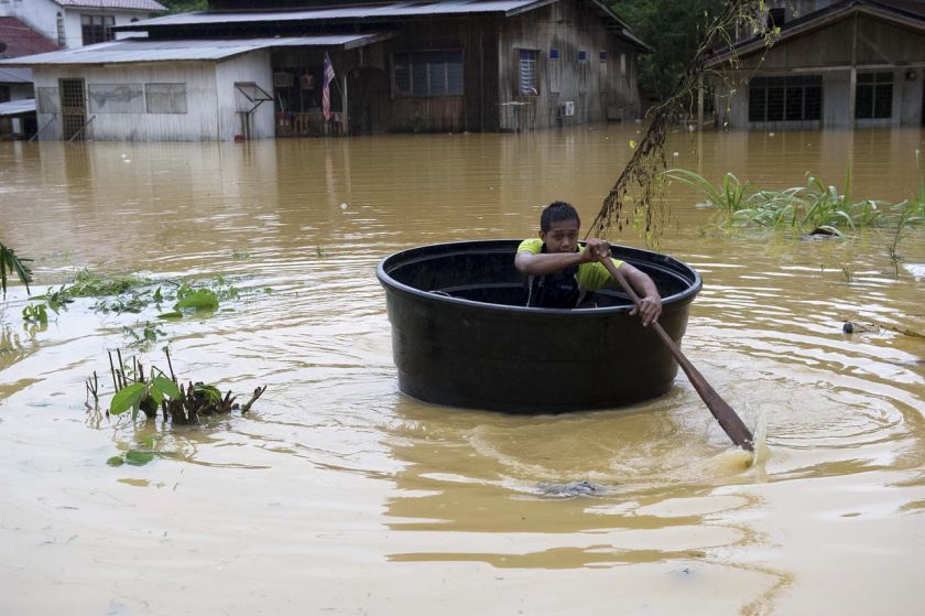 A resident of Kampung Keroh uses a water tank to save himself as flood waters continue to rise, December 25, 2014. u00e2u20acu2022 Bernama pic