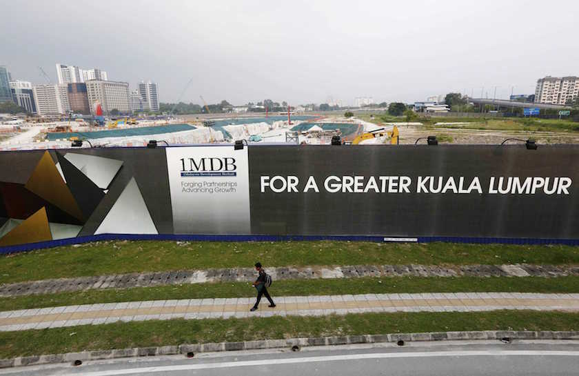 A man walks past a 1 Malaysia Development Berhad (1MDB) billboard at the funds flagship Tun Razak Exchange development in Kuala Lumpur, in this March 1, 2015 file photo. u00e2u20acu201d Reuters pic