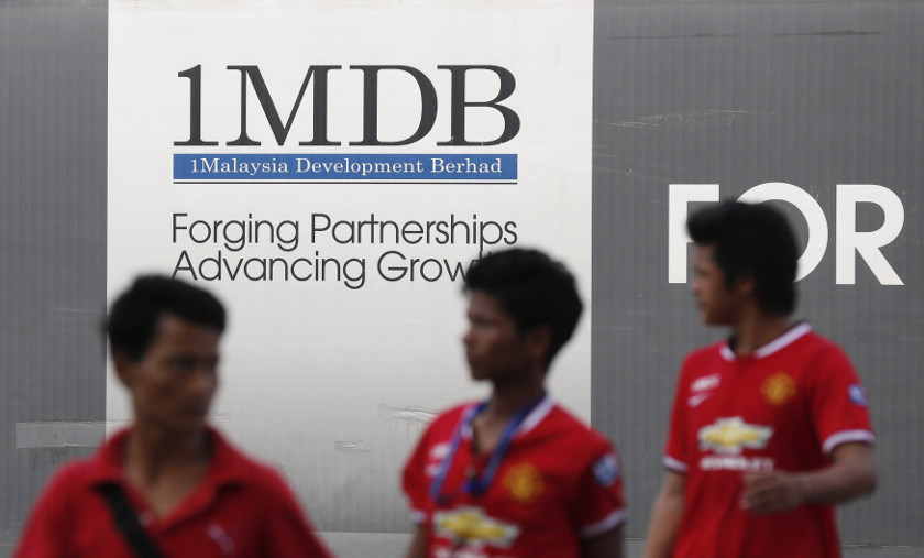Men walk past a 1 Malaysia Development Berhad (1MDB) billboard at the funds flagship Tun Razak Exchange development in Kuala Lumpur March 1, 2015. u00e2u20acu201d Reuters pic