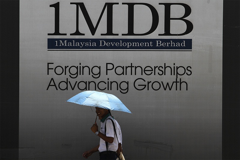 A man walks past a 1 Malaysia Development Berhad (1MDB) billboard in Kuala Lumpur, March 30, 2015. — Picture by Yusof Mat Isa