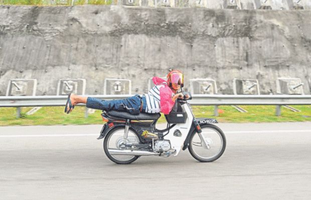 A young Mat Rempit doing dangerous stunts on a highway in Kuala Pilah. u00e2u20acu201d Picture by Zuraneeza Zulkifli