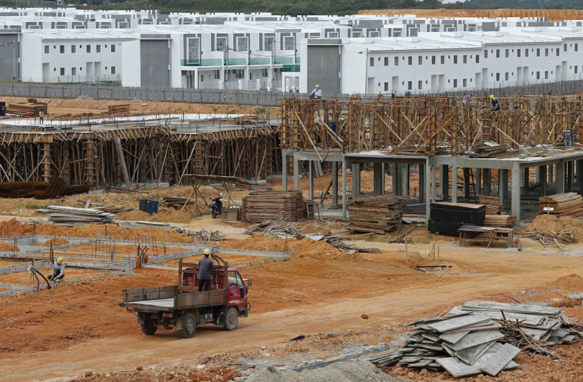 Workers build homes and shops in a partially completed new township about 40km away from Pengerang Integrated Petroleum Complex in Pengerang, Johor, February 4, 2015. u00e2u20acu201d Reuters pic
