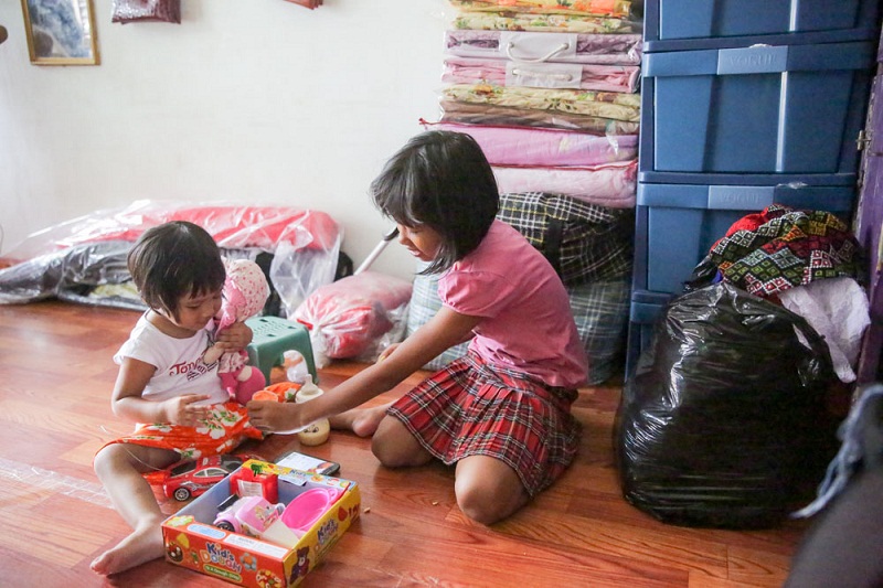 The two daughters playing in the shared area of their living space.