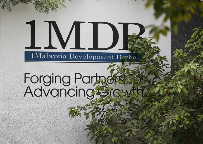 Foliage partly covers a 1Malaysia Development Berhad (1MDB) billboard at the funds flagship Tun Razak Exchange development in Kuala Lumpur, July 3, 2015. u00e2u20acu201d Reuters pic
