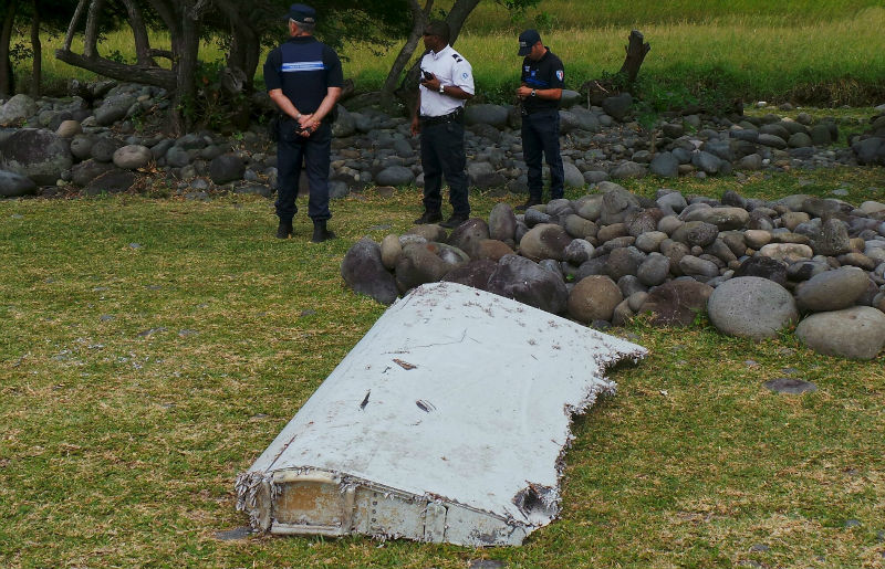 French gendarmes and police stand near a large piece of plane debris which was found on the beach in Saint-Andre, on the French Indian Ocean island of La Reunion, July 29, 2015. u00e2u20acu201d Reuters pic