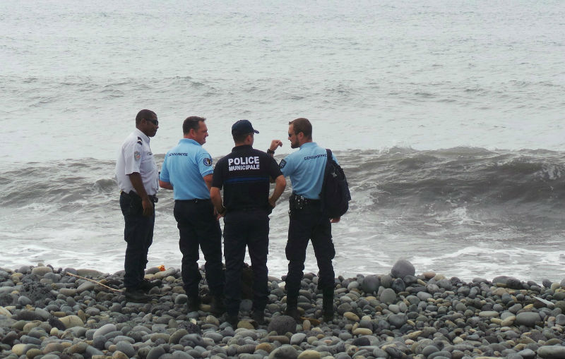 French gendarmes and police stand on the beach where a large piece of plane debris was found in Saint-Andre, on the French Indian Ocean island of La Reunion, July 29, 2015. u00e2u20acu201d Reuters pic
