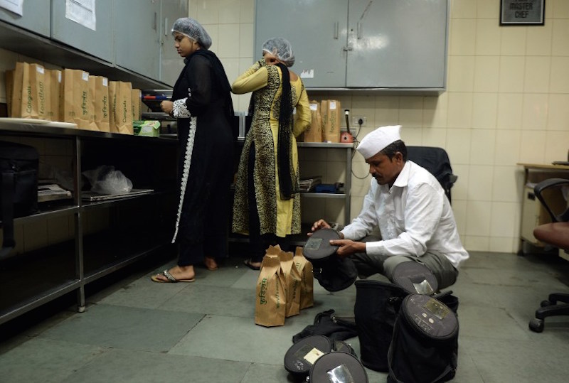 In this photograph taken on September 2, 2015, an Indian dabbawallah packs lunch boxes at an online meal delivery firm’s kitchen in Mumbai. — AFP pic
