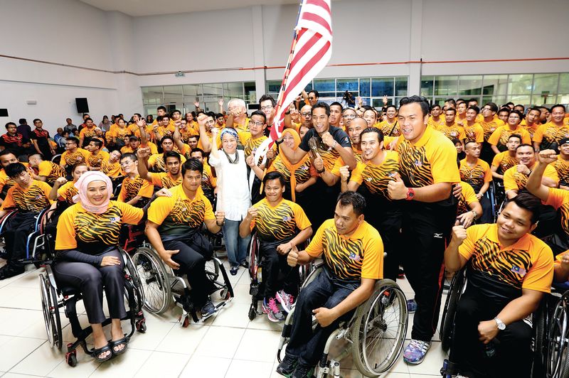 The Asean Para Games contingent pose after receiving the Jalur Gemilang from Khairy.  u00e2u20acu201d Bernama pic
