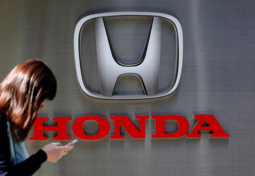 A woman using her mobile phone walks past a logo of Honda Motor Co outside the companyu00e2u20acu2122s dealership in Tokyo January 16, 2016. u00e2u20acu201d Reuters pic