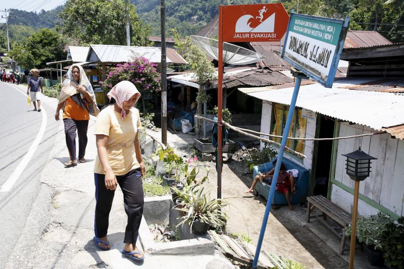Women walk near a sign on their way home marking a tsunami evacuation route a day after a 7.8 magnitude quake struck far out at sea near Padang, West Sumatra province March 3, 2016. u00e2u20acu201d Reuters pic