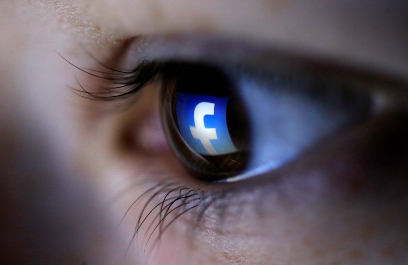 A picture illustration shows a Facebook logo reflected in a person’s eye.  — Reuters pic