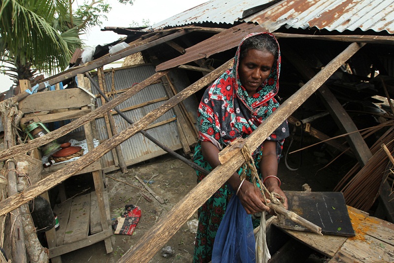 A Bangladeshi woman tries to fix her destroyed house after a killer cyclone wrecked thousands of homes, in Patuakhli 200 km south from Dhaka on May 17, 2013. u00e2u20acu201d AFP pic