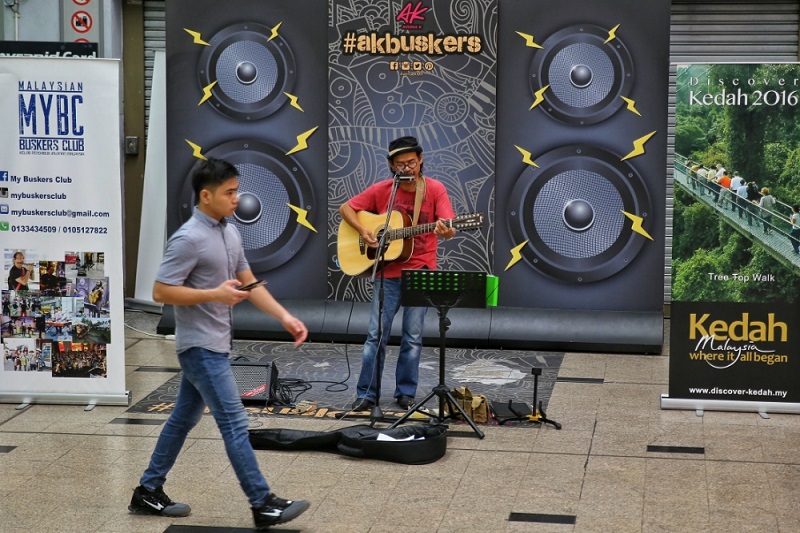 A man busks next to the KLCC LRT station in Kuala Lumpur, July 11, 2016. — Picture by Saw Siow Feng 