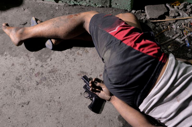 The body of a man is pictured with a gun under his hand, whom police said was killed during a drug bust operation on 'Shabu, (meth), in Manila August 18, 2016. u00e2u20acu201d Reuters pic