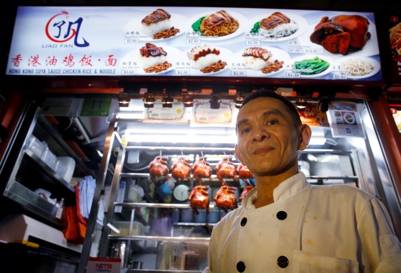 Hawker Chan Hong Meng, who earned a Michelin star for his soya sauce chicken rice and noodle, poses for the media outside his stall at a food market in Singapore, July 22, 2016. u00e2u20acu2022 Reuters pic