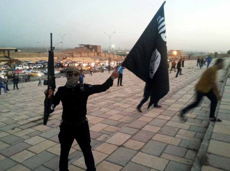 File picture shows a fighter of the Islamic State of Iraq and the Levant (ISIL) holding an ISIL flag and a weapon on a street in the city of Mosul, Iraq June 23, 2014. u00e2u20acu201dReuters pic