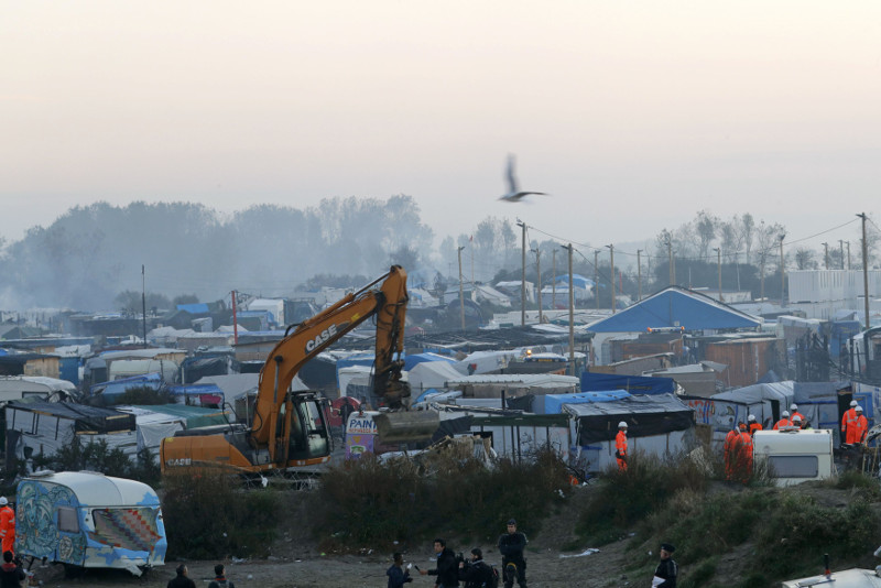 A bulldozer is used to remove debris as workmen tear down makeshift shelters during the dismantlement of the camp called the ‘Jungle’ in Calais, France, October 27, 2016. — Reuters pic