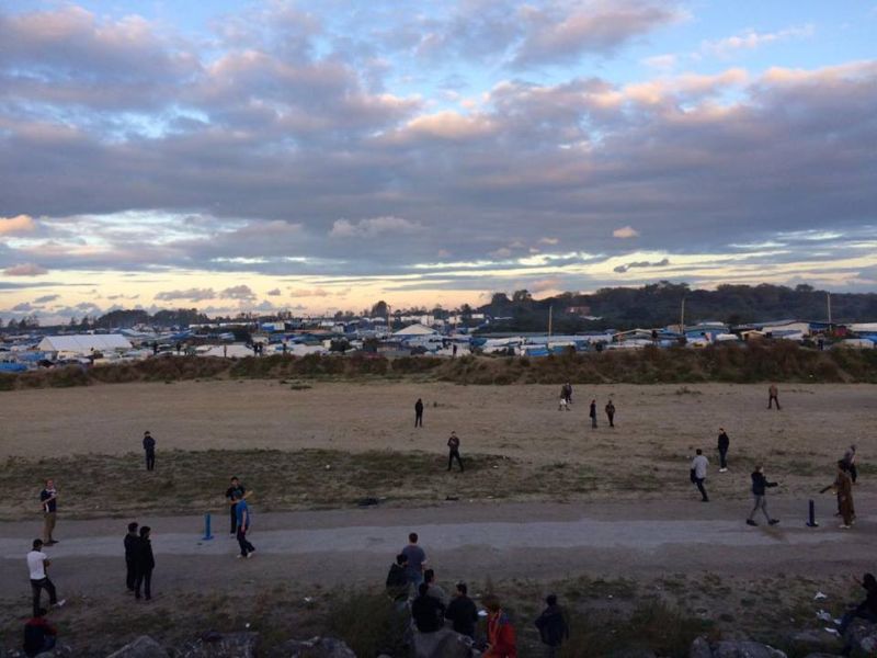 A cricket match between volunteers and residents of the Jungle which can be seen in the background. ― Pictures courtesy of Matthew and Edith