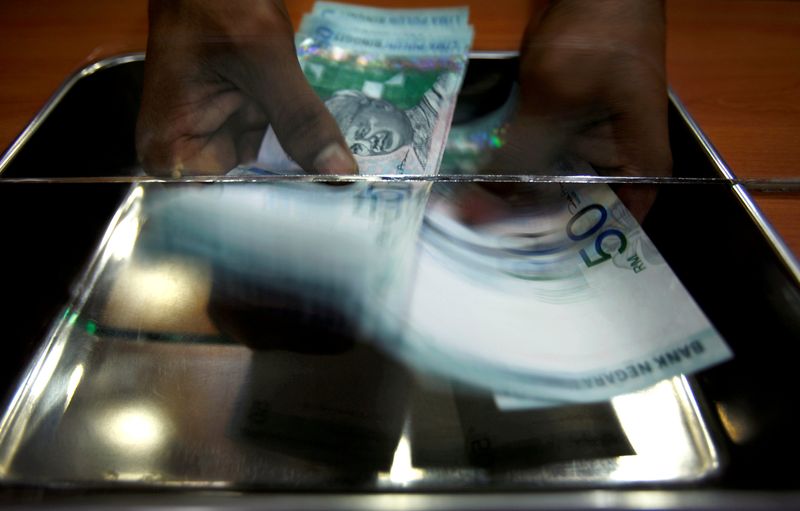 A money changer counts ringgit at a shop in Putrajaya. u00e2u20acu201d Reuters pic