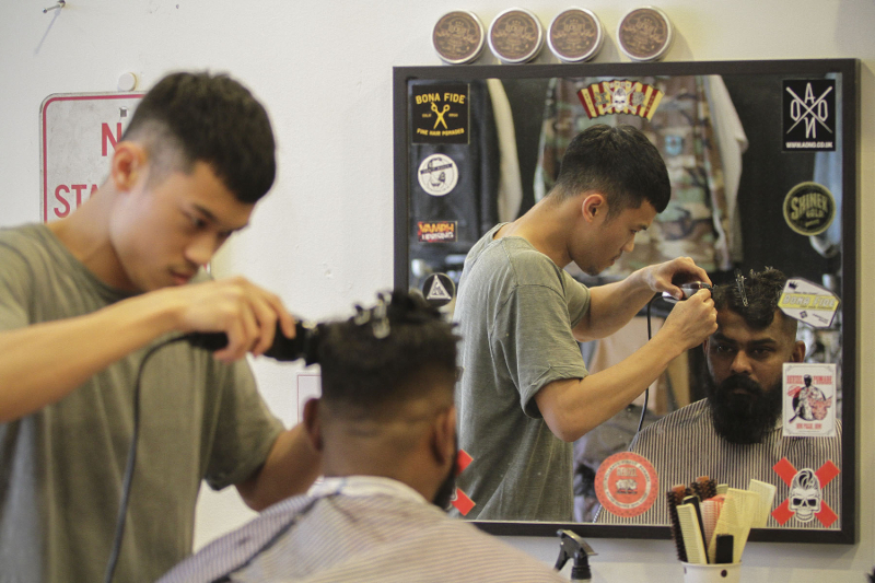 A barber at Othrs giving his client a pompadour haircut. u00e2u20acu201d Picture by Yusof Mat Isa