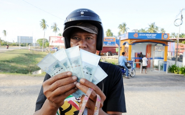 Orang Asli dari Kampung Api Larat, Atan Tenggang, 49, menunjukkan wang Bantuan Rakyat 1Malaysia (BR1M) RM250 selepas mengambilnya di mesin ATM berdekan Balai Polis Nenasi.u00c2u00a0u00e2u20acu201du00c2u00a0Foto Bernama