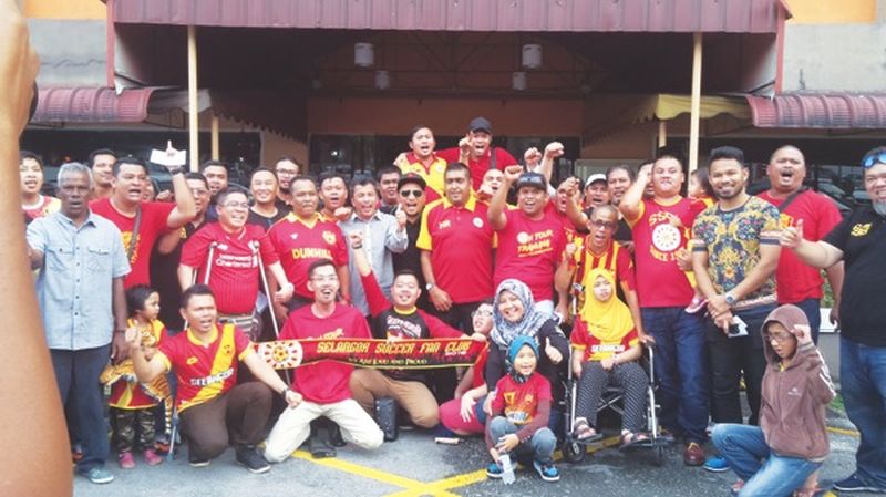 Nizaruddin Yusof (standing, second right) poses for a photograph with Selangor fans. u00e2u20acu201d Picture by Wan Noriza Meor Idris