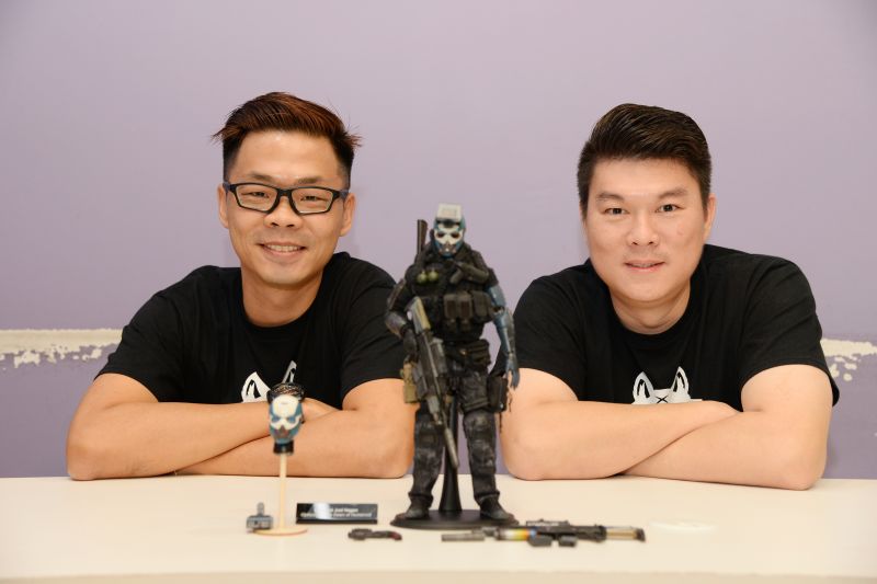 Ethan Tang (left) and Aaron Leow, the people behind Jackal X, pose with 'Joel Hagan', one of two prototype figures. u00e2u20acu2022 Picture by KE Ooi