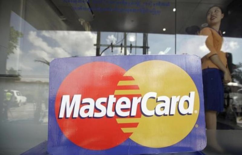 An employee stands behind a MasterCard logo during the launch of the international credit card issuer's first ATM transaction in Myanmar, in Yangon November 15, 2012. REUTERS/Soe Zeya Tun