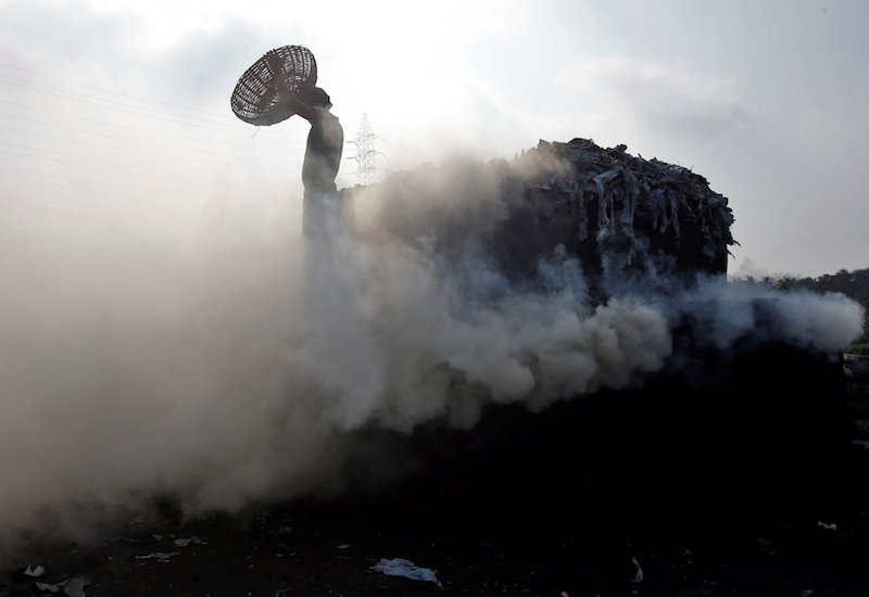 A labourer carries an empty basket after putting leather scrap on a burning oven for making fertilisers at a factory on the outskirts of Kolkata February 22, 2017. u00e2u20acu201d Reuters pic