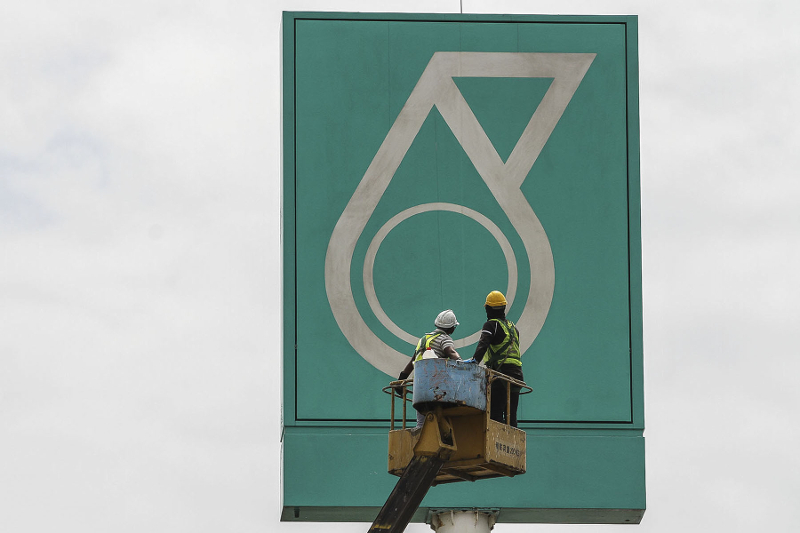 Workers work on a signage bearing a Petronas logo in Kuala Lumpur March 12, 2017. u00e2u20acu201d Picture by Yusof Mat Isan