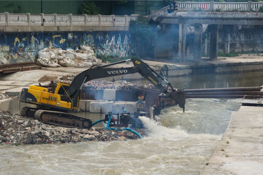 Workers dredge garbage and silt from a storm drain near the Pasar Seni LRT station following flash floods last week. u00e2u20acu201d Picture by Mukhriz Hazim