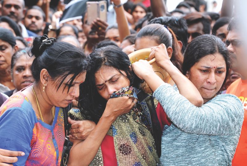 D. Shanti (centre) was inconsolable while performing a ritual for her son Nhaveen during his funeral on Friday. u00e2u20acu201d Bernama pic  