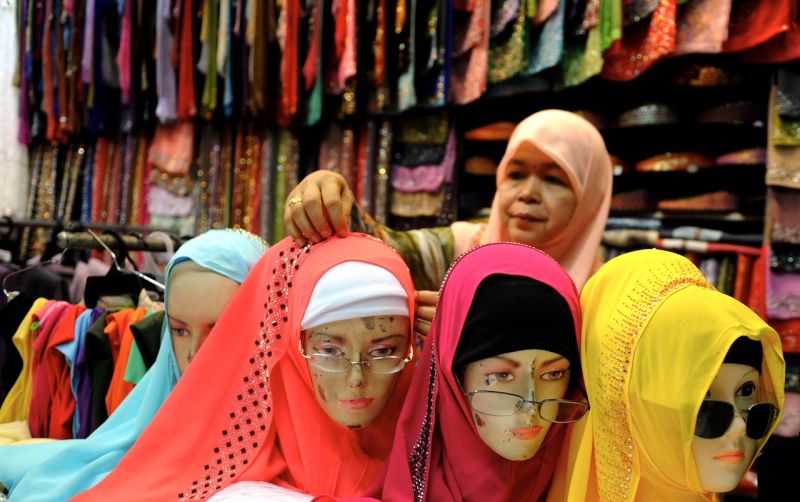 Seorang pekerja Elmi Sahsurah membetulkan tudung pelbagai warna-warni yang dipakai pada patung sambil menunggu pelanggan di Bazaar Chowrasta, Jalan Penang, 2 Jun 2017. u00e2u20acu2022 Foto Bernama