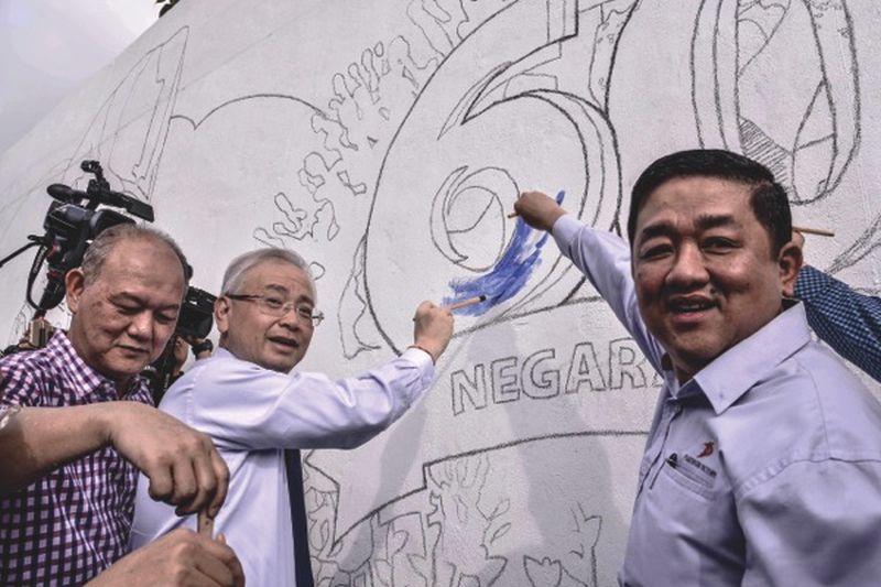 Datuk Seri Dr Wee Ka Siong (centre) paints the first touches of blue on the mural with Yew (left) and Gan. u00e2u20acu201d Picture by Hari Anggara