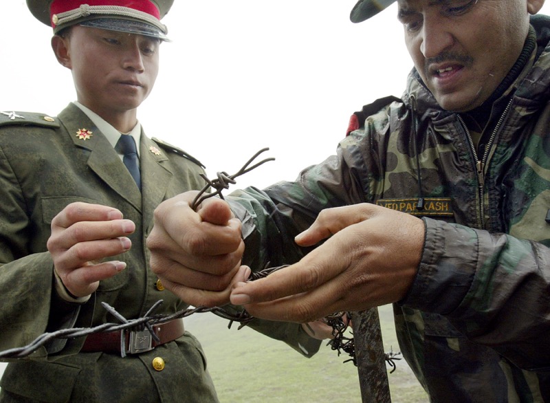 This file photo taken on July 5, 2006 shows a Chinese soldier (left) and Indian soldier placing a barbed wire fence following a meeting of military representatives at the Nathu La border crossing between India and China in India's northeastern Sikkim stat