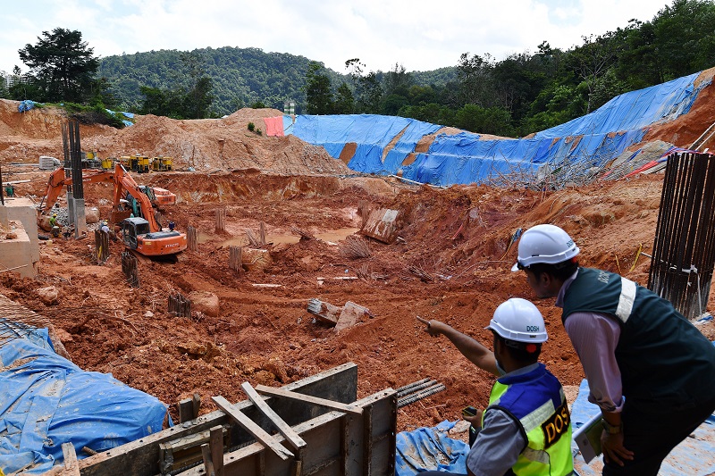 Workers from the Department of Occupational Safety and Health examine the site where the deadly landslide occurred at Tanjung Bungah, Penang October 24, 2017. u00e2u20acu201d Bernama pic