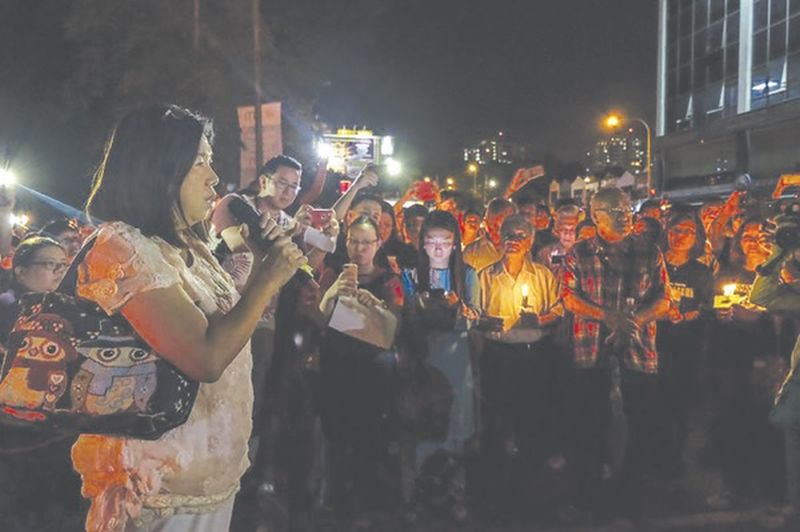 Raymond Kohu00e2u20acu2122s wife, Susanna Liew, addresses a crowd at a candlelight vigil outside the Selangor police headquarters in Shah Alam in March. u00e2u20acu201d Picture by Yusof Mat Isa