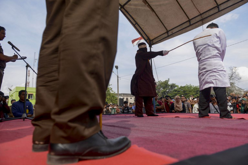 Jono Simbolon (right), an Indonesian Christian, is flogged in front of a crowd outside a mosque in Banda Aceh, Aceh province, on January 19, 2018. u00e2u20acu201d AFP pic