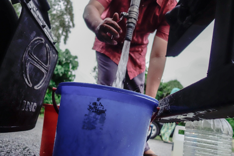 Residents from Taman Bukit Kuchai in Puchong fill up container with water due to water disruption in Klang valley March 7, 2018. u00e2u20acu201d Picture by Shafwan Zaidon