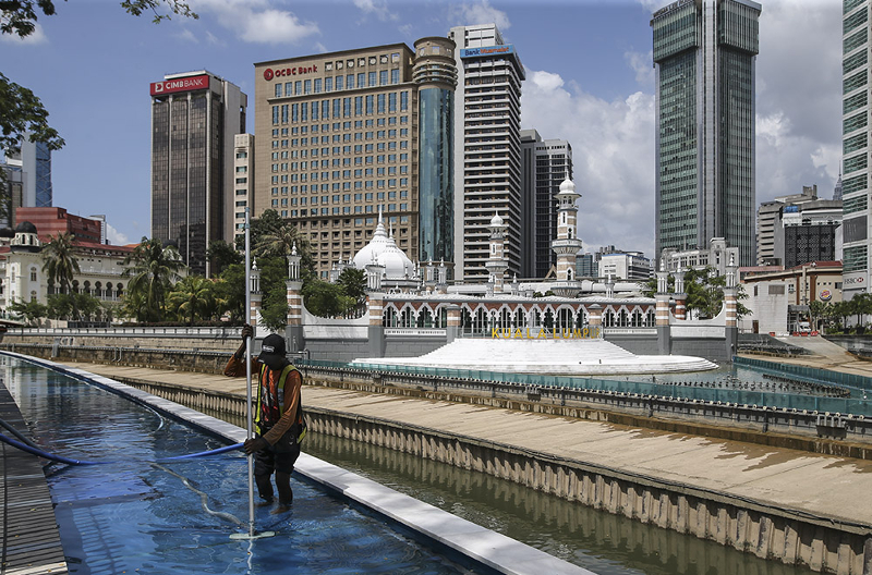 A worker cleans the River of Life and Blue Pond project at Jamek Mosque in Kuala Lumpur March 11, 2018. u00e2u20acu201d Picture by Azneal Ishak