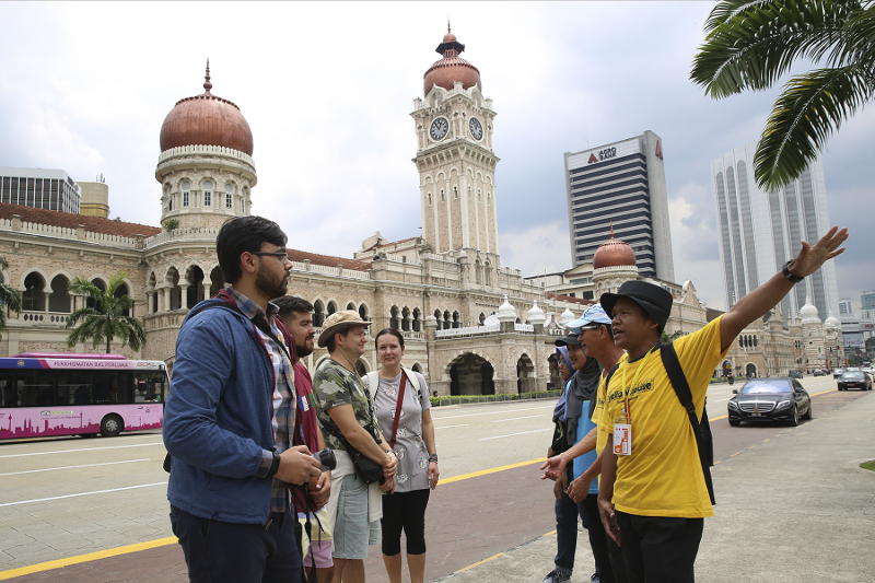 Rosfadliza and Kam guiding tourists from India and Europe, at Dataran Merdeka. — Pictures by Yusof Mat Isa