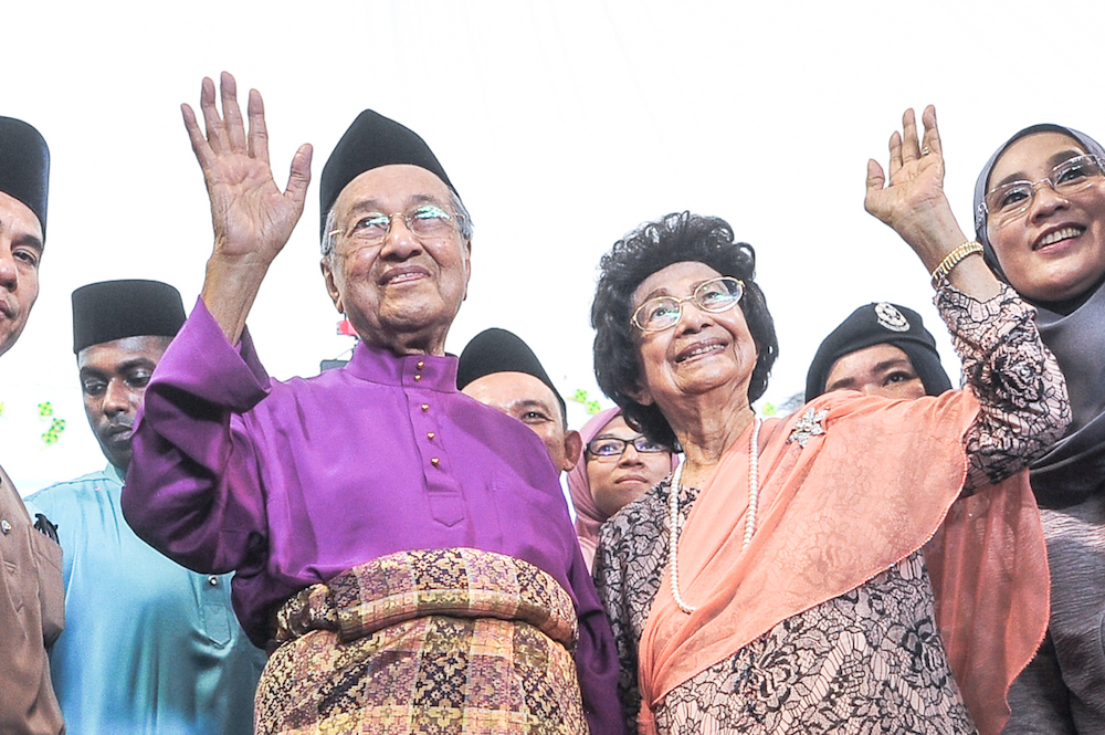 Tun Dr Mahathir Mohamad and Tun Dr Siti Hasmah Mohd Ali wave during the prime minister’s Aidilfitri open house in Putrajaya June 15, 2018. — Picture by Shafwan Zaidon 